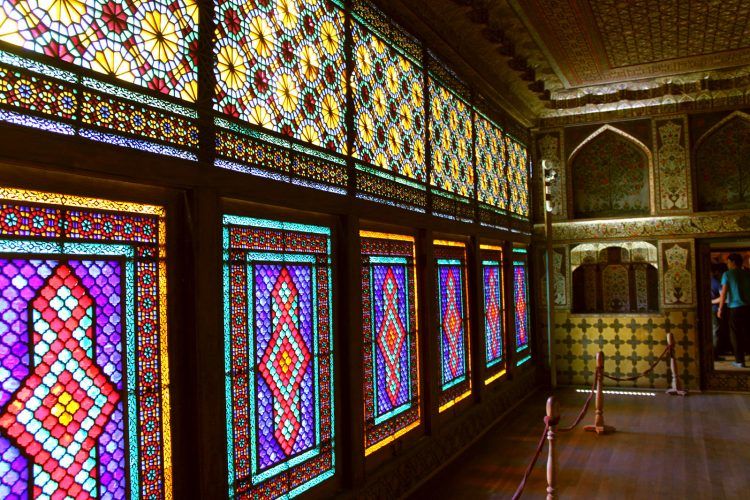 A small room with a floor-to-ceiling set of stained glass windows.