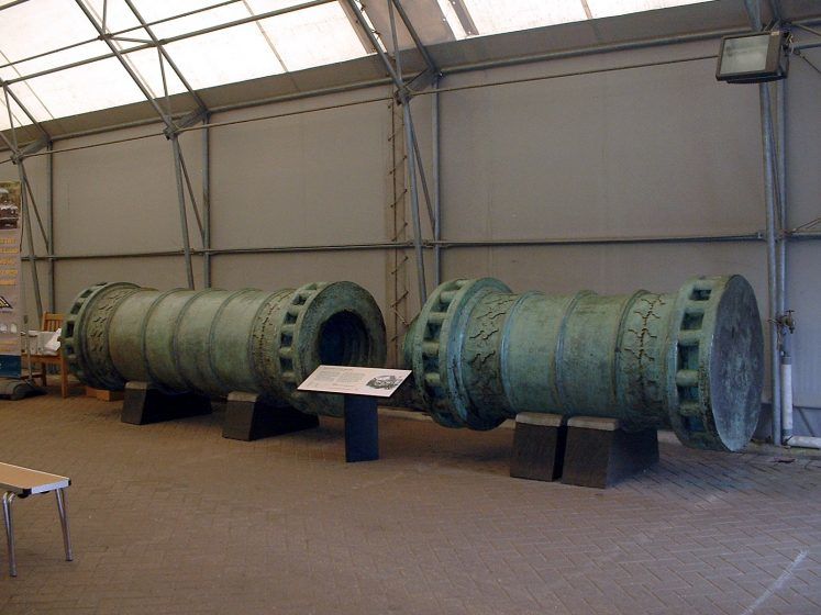A large rusted iron cannon in two pieces