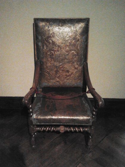 A chair with ornate leather covers.