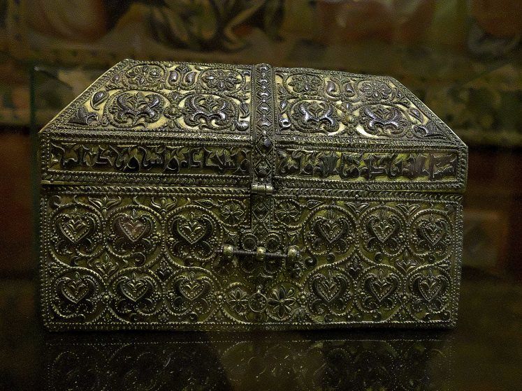 A silver and gold ornamental chest with Arabic inscriptions.