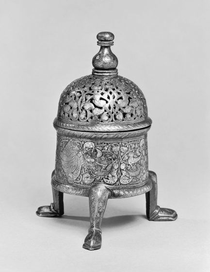 A silver round insence burner with three legs.