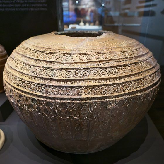 A brown jar with geometric designs.