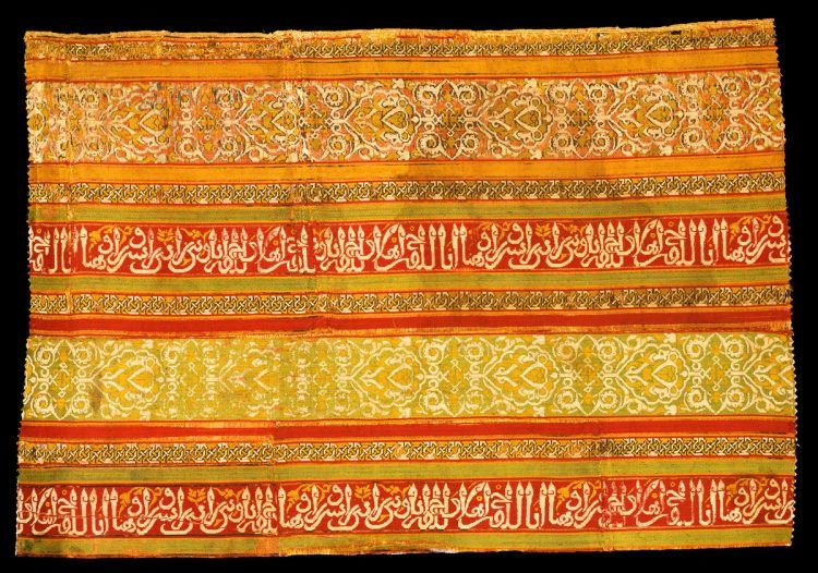 A bright yellow and orange silk textile with Arabic lettering.