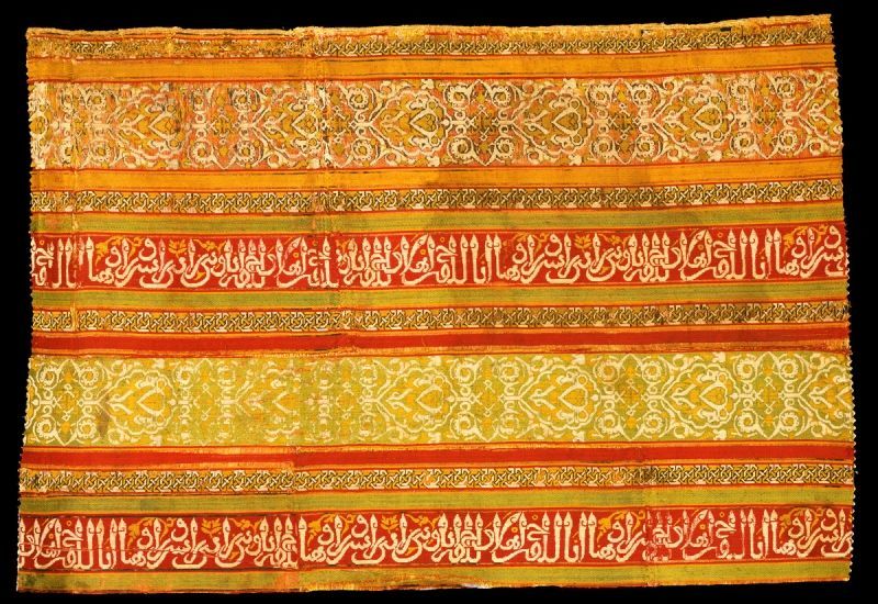 A bright yellow and orange silk textile with Arabic lettering.